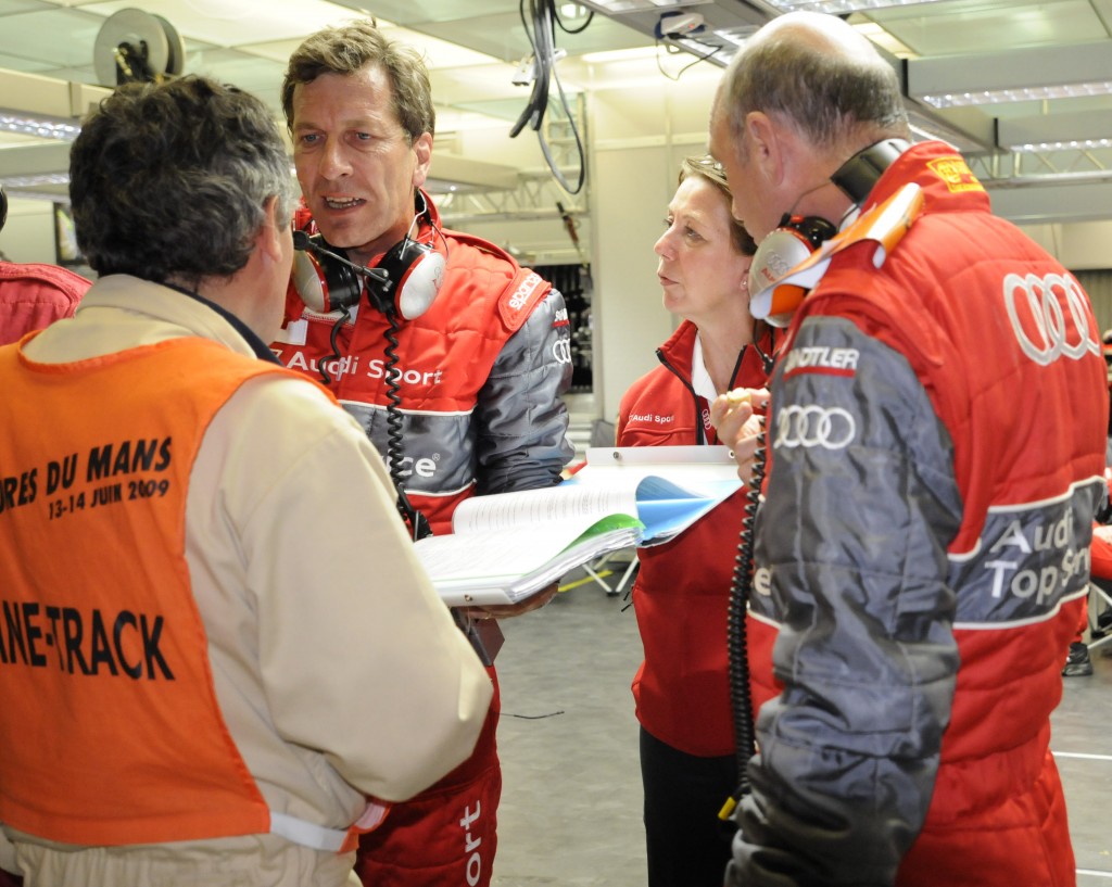 Dr. Wolfgang Ullrich (at right) with crew (and rulebook) and ACO official review pit stop repairs.